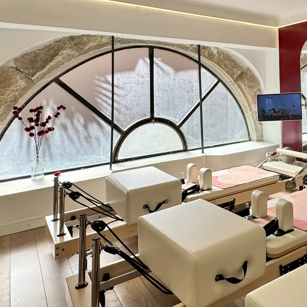 Salle de Pilates Reformer du Studio Yuzu à Grasse, sous la fenêtre en arc en pierre